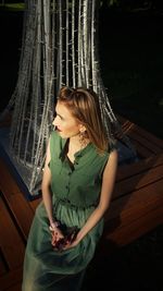 Young woman looking down while sitting outdoors