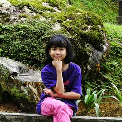 Portrait of smiling girl sitting outdoors