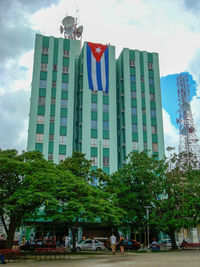 Low angle view of flags hanging against buildings in city