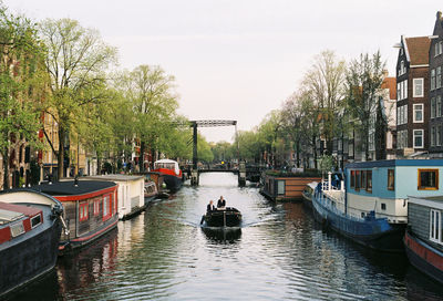 Boats in canal against clear sky