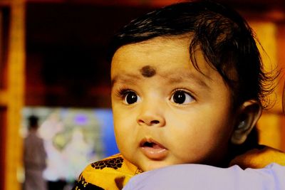 Close-up of cute baby boy looking away