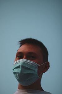 Portrait of a serious young man against blue background