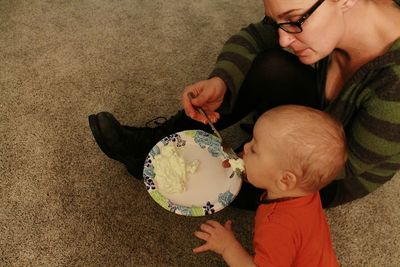 Mother feeding son at home