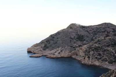 Scenic view of sea and mountains against clear sky