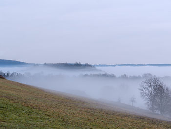 Scenic view of field against sky during foggy weather