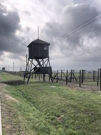 Lifeguard tower on field against sky