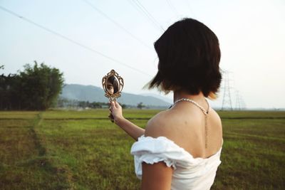 Rear view of woman standing on field