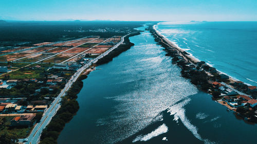 High angle view of cityscape by sea against sky