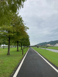Road amidst trees against sky