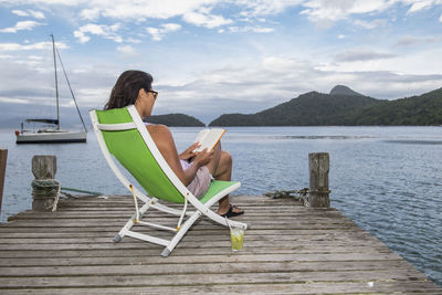 Woman relaxing on pier on the tropical island of ilha grande