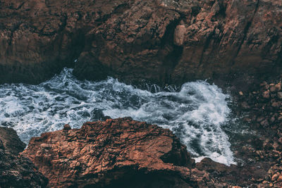 High angle view of river flowing by rocks