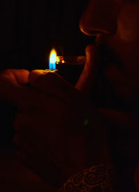 Close-up of hand holding lit candle