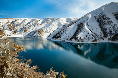 Lake kezenoy-am in the mountains in winter. scenic view of snowcapped mountains against sky