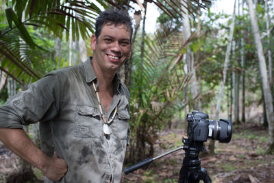 Portrait of a smiling young man holding camera