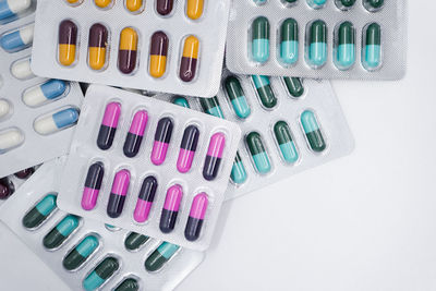 Close-up of multi colored blister pack capsules against white background