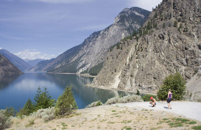 Man and woman on field by seton lake against mountains