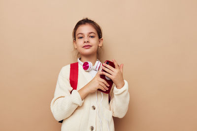 Young woman using mobile phone against pink background