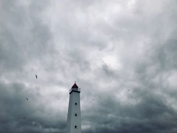 Low angle view of lighthouse against cloudy sky