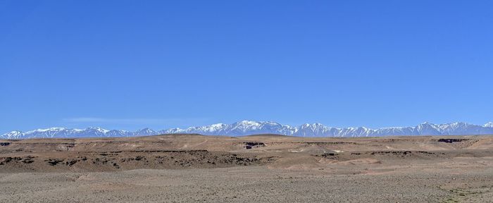 Scenic view of desert against clear blue sky