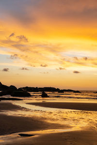 Scenic view of sea against dramatic sky during sunset