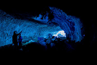 Silhouette of man standing in cave