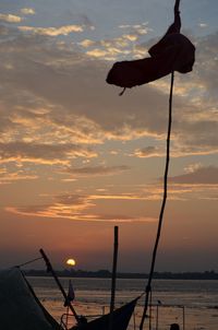 Silhouette lifeguard hut against sky during sunset