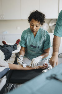 Male and female surgeons operating young woman in hospital