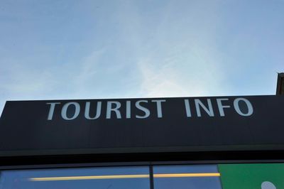 Low angle view of information sign against sky