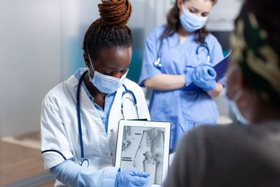 Portrait of female doctor holding dentures while standing in office