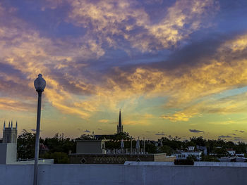 Buildings against cloudy sky at sunset