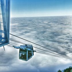 Low angle view of overhead cable car against sky