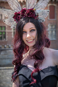 Portrait of smiling woman in costume standing outdoors