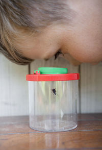 Boy looking at insect in jar