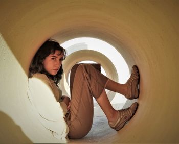 Portrait of woman sitting in concrete tube