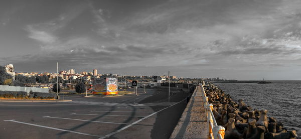 Panoramic view of city by sea against sky