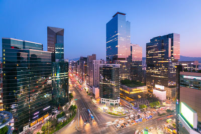 Illuminated city buildings against clear sky