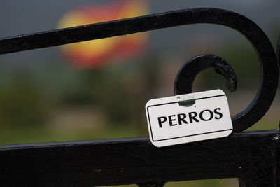 Close-up of information sign on railing