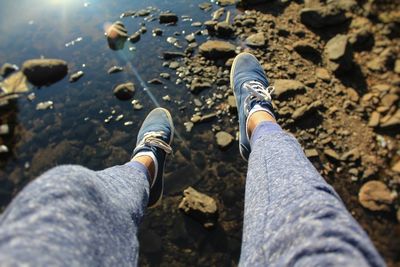 Low section of man wearing shoes over lake