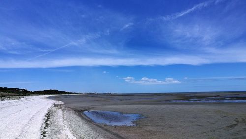 Scenic view of beach against blue sky