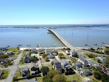 Aerial view of houses and sea against clear blue sky