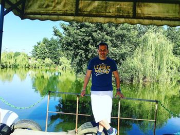 Portrait of smiling man standing by lake