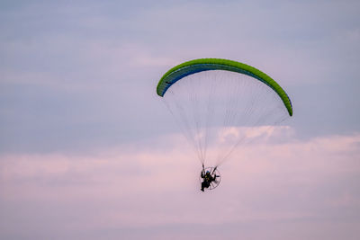 Person paragliding against sky