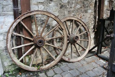 Wagon wheels on footpath against wall