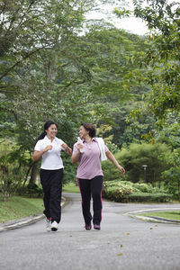 Friends running on footpath at park