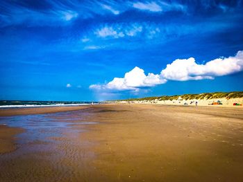 Scenic view of beach against blue sky