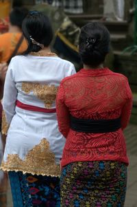 Rear view of women standing outdoors in balinese clothing
