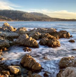 Rocks in sea against sky