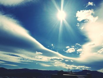 Low angle view of sun shining in sky