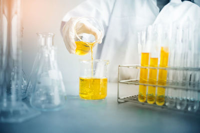 Midsection of scientist examining chemical in laboratory