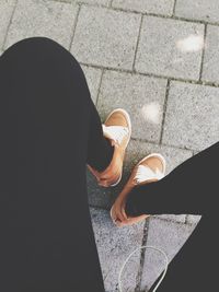 Low section of woman standing on tiled floor